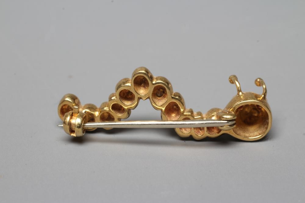 AN 18CT GOLD NOVELTY CATERPILLAR BROOCH set with two facet cut ruby eyes and with six pairs of Image