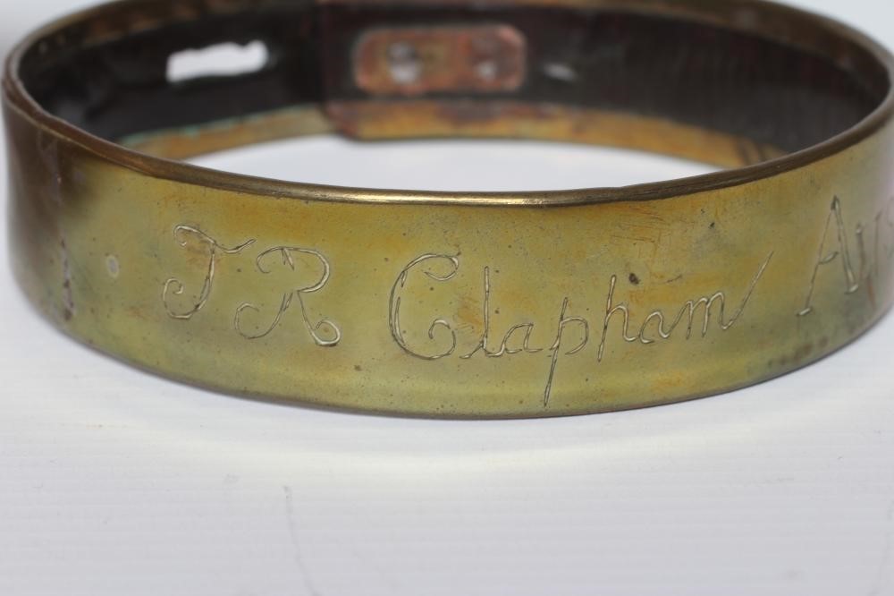 A BRASS DOG COLLAR, early 19th century, engraved 'T R Clapham, Austwick Hall', leather lined, 4 1/2" Image