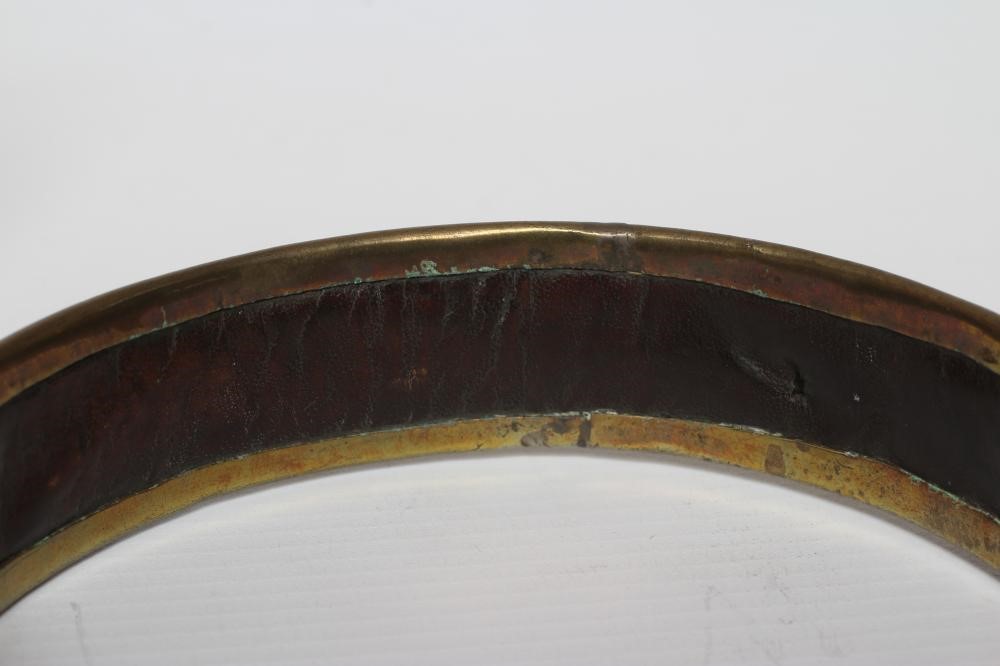 A BRASS DOG COLLAR, early 19th century, engraved 'T R Clapham, Austwick Hall', leather lined, 4 1/2" Image