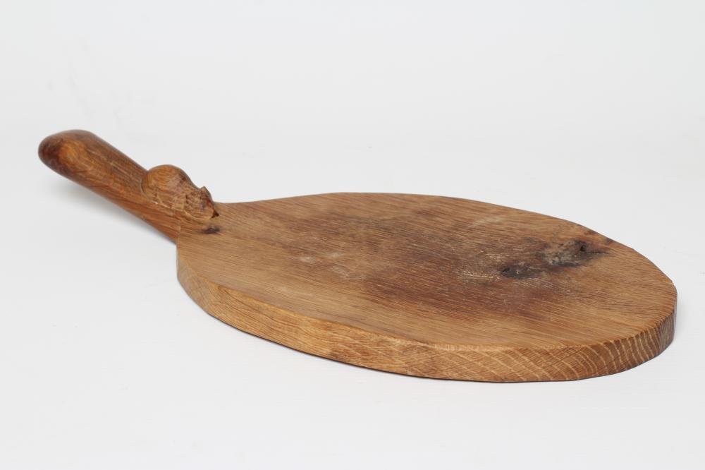 A ROBERT THOMPSON ADZED OAK OVAL CHEESEBOARD with carved mouse trademark, 15" long (Est. plus 24% Image