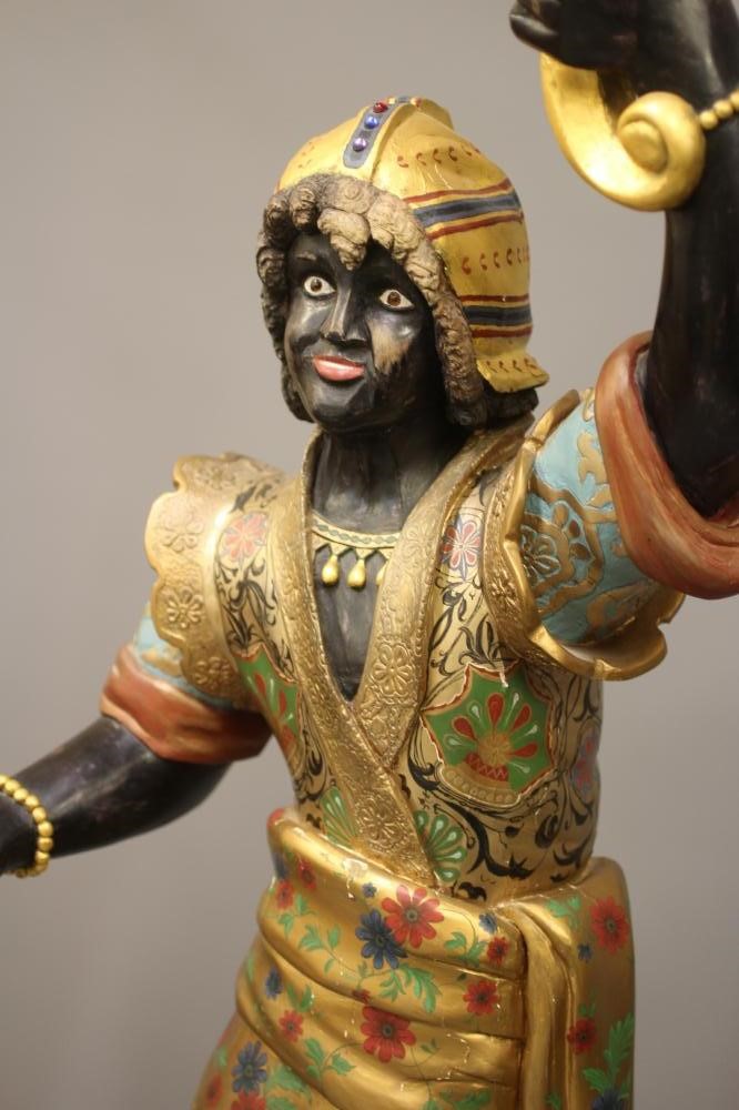 A PAIR OF HAND CARVED POLYCHROME AND GILDED TORCHERE BLACKAMOORS Image