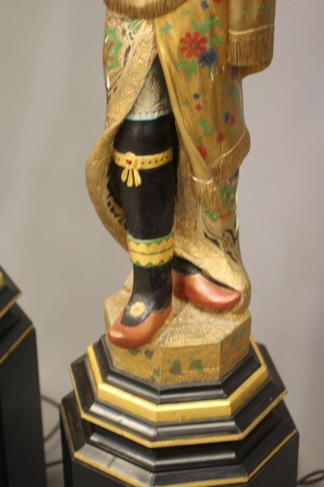 A PAIR OF HAND CARVED POLYCHROME AND GILDED TORCHERE BLACKAMOORS Image
