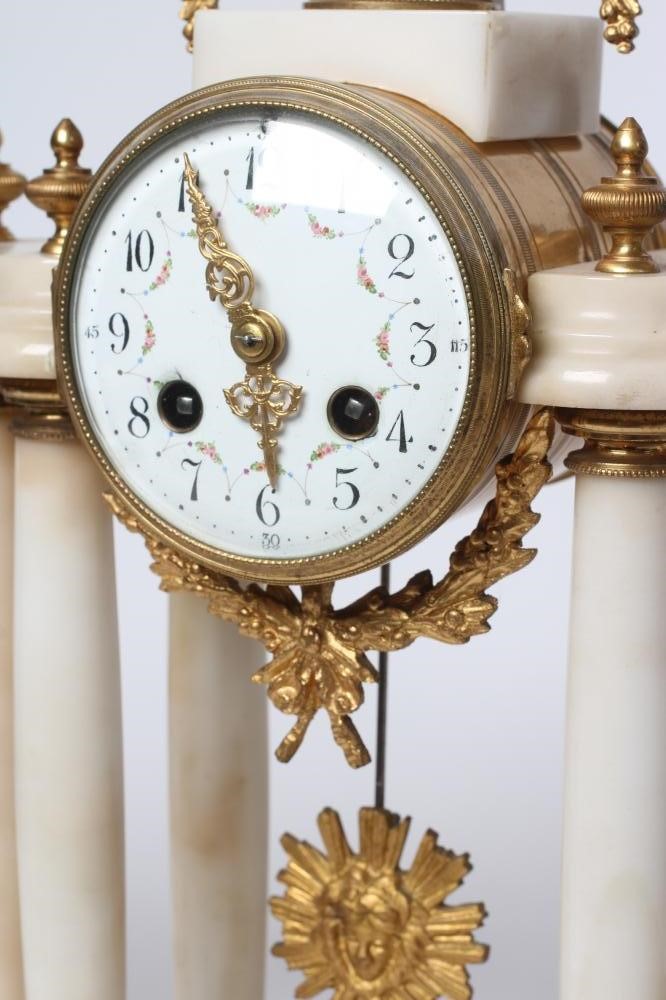 A FRENCH WHITE ONYX AND GILT METAL CLOCK GARNITURE Image