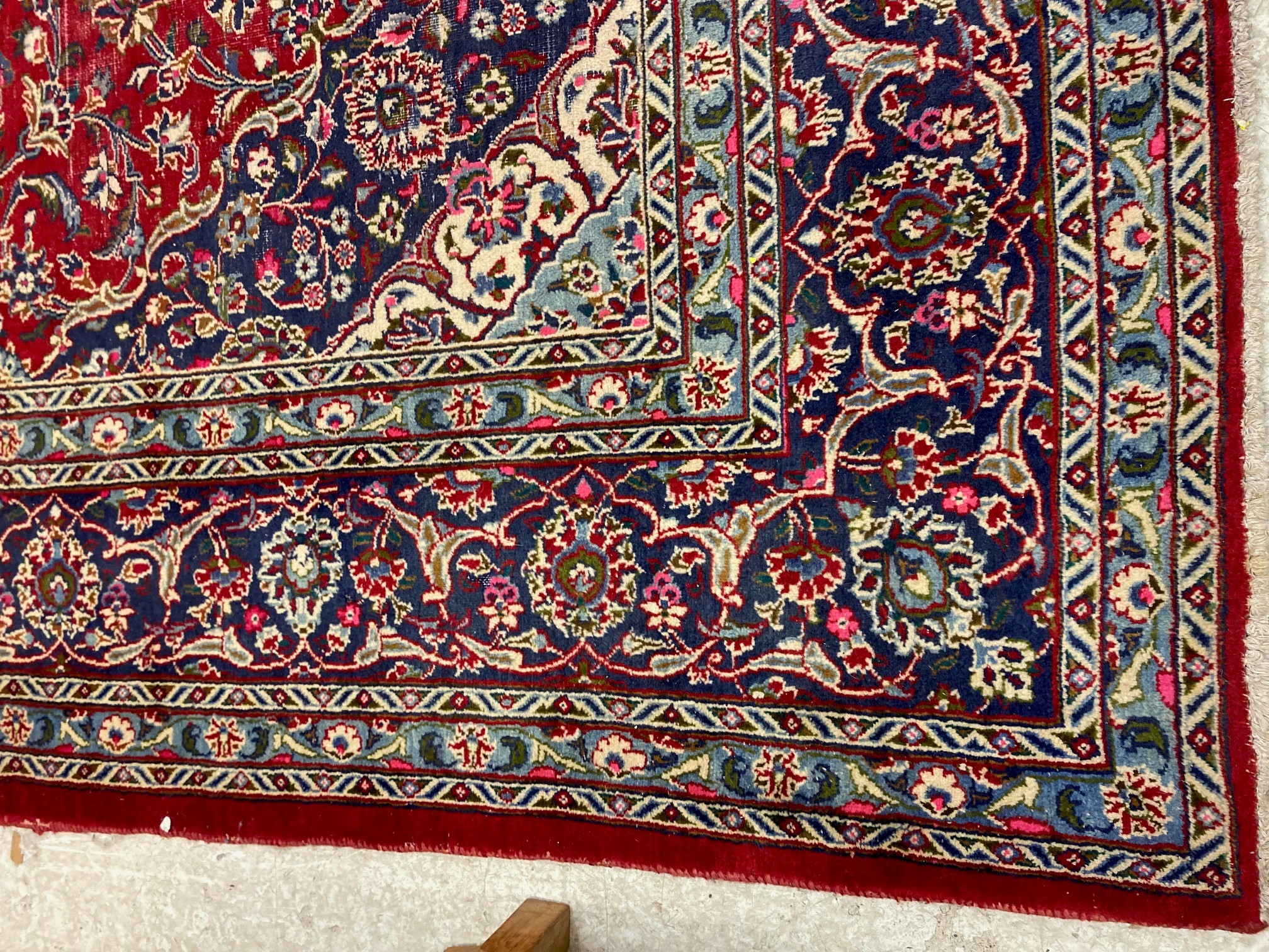 A KASHAN RUG, with central floral medallion on a red ground surrounded by light and dark blue floral Image