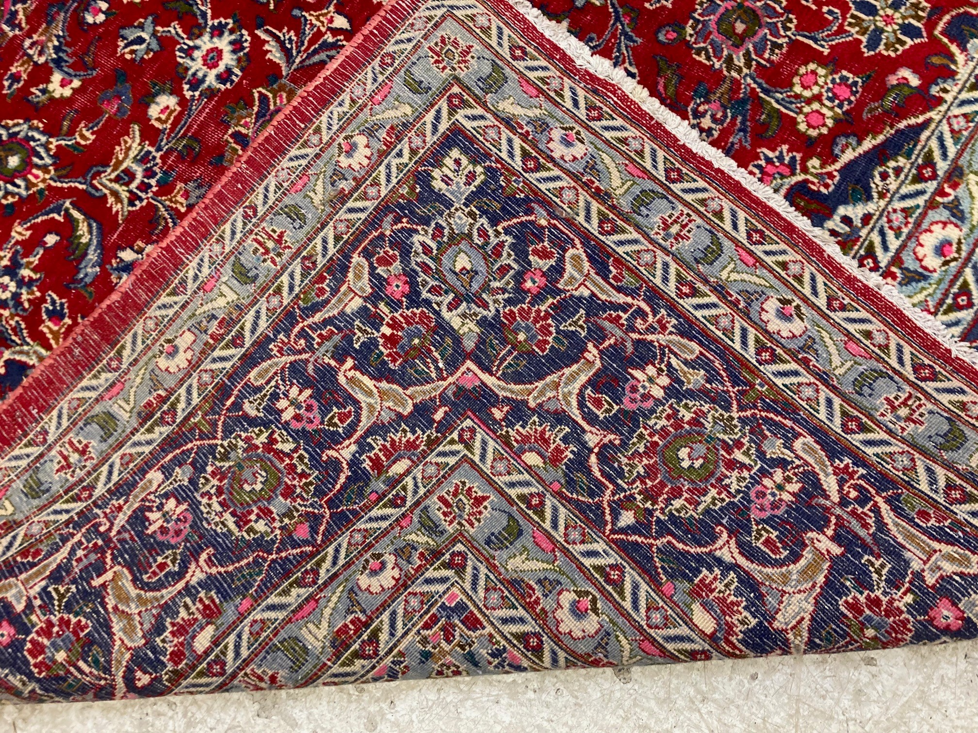 A KASHAN RUG, with central floral medallion on a red ground surrounded by light and dark blue floral Image