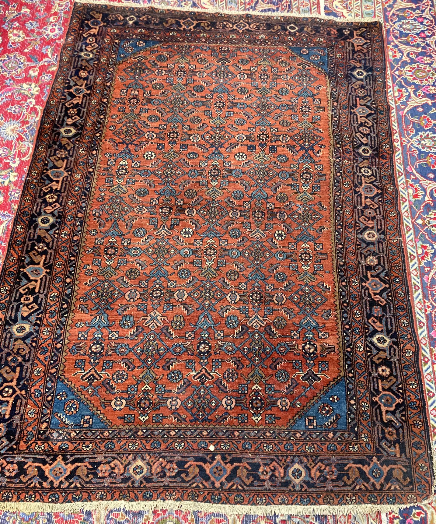 A NORTHWEST PERSIAN TRIBAL RUG with dark red central field decorated with floral tendrils contained Image
