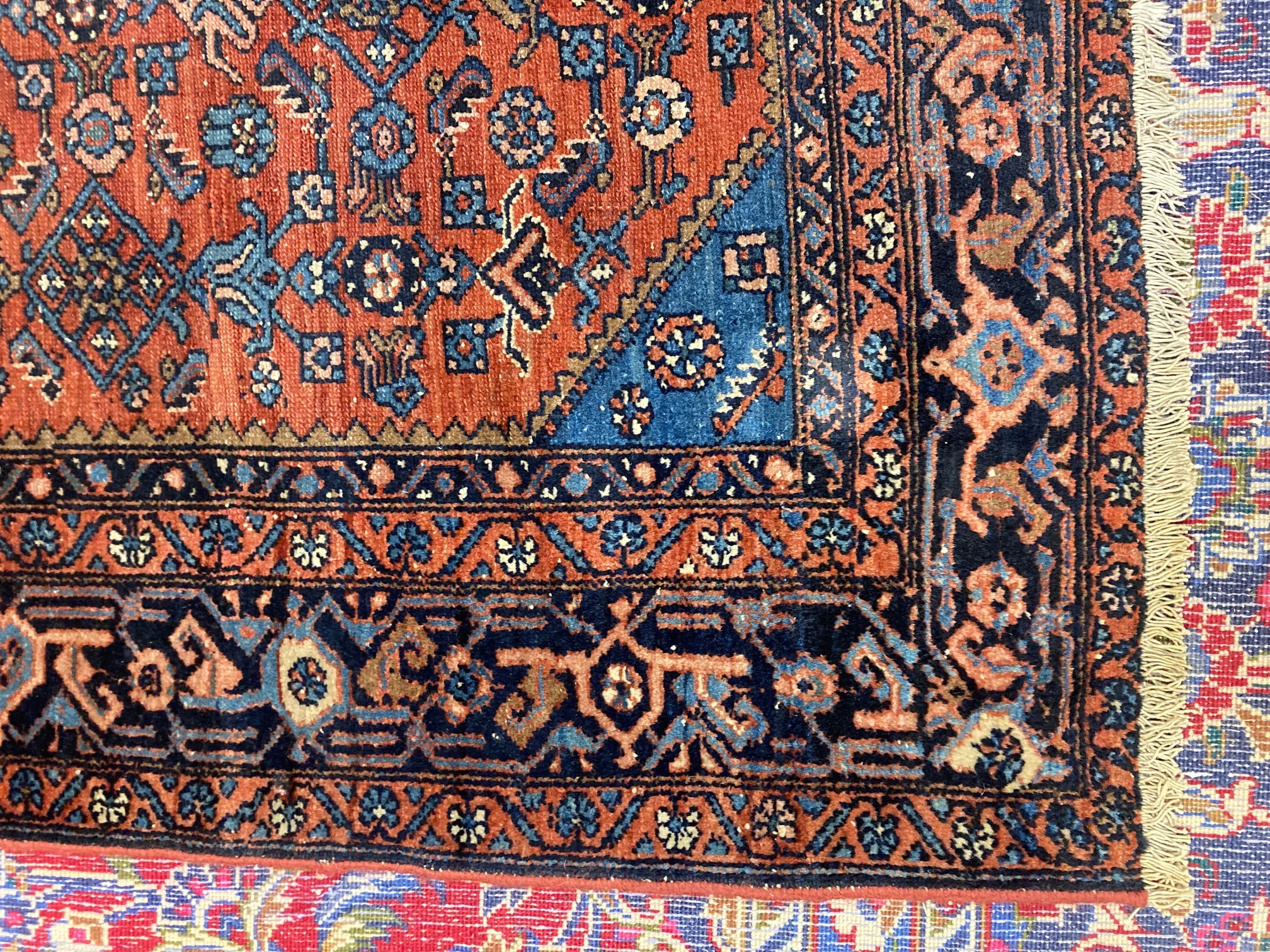 A NORTHWEST PERSIAN TRIBAL RUG with dark red central field decorated with floral tendrils contained Image