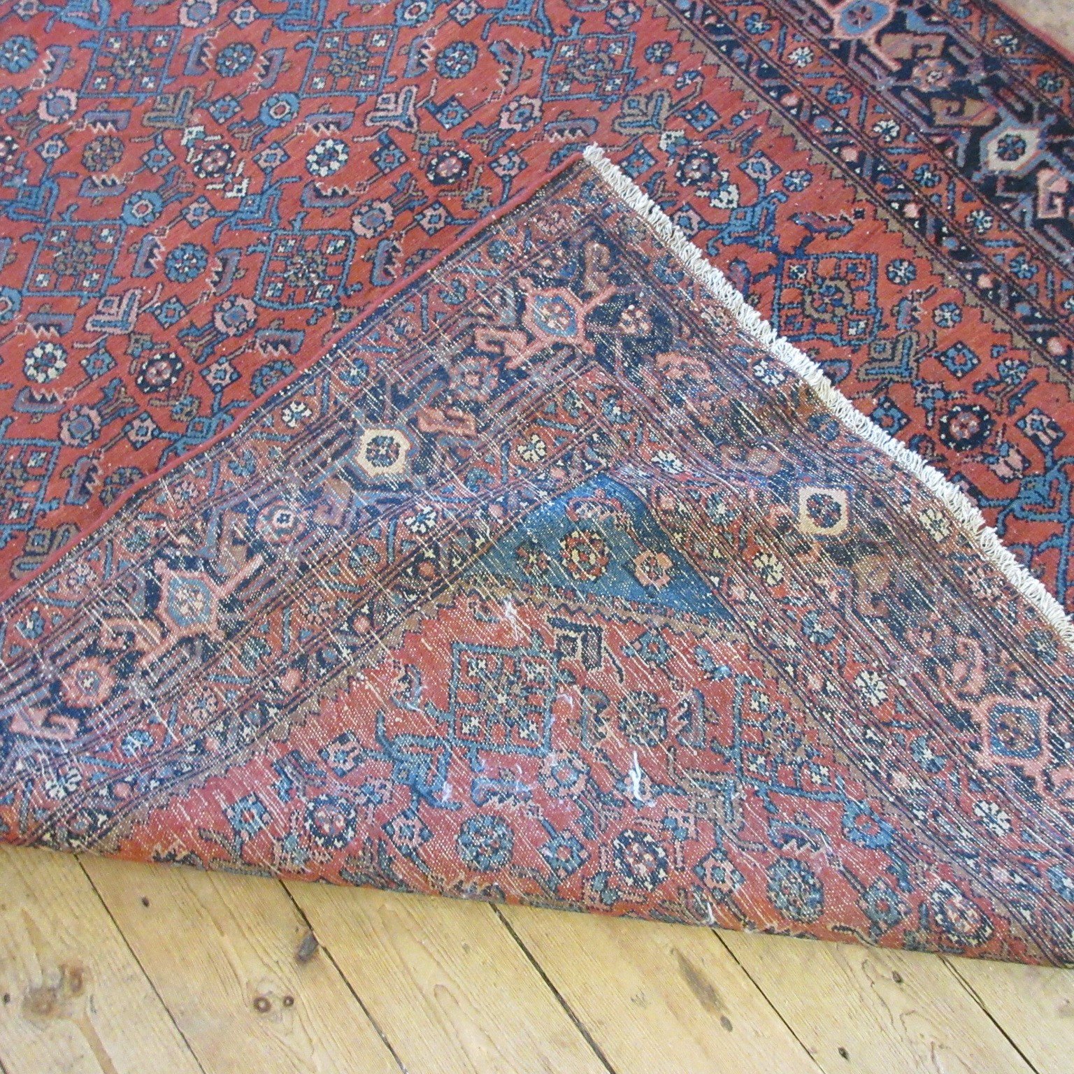 A NORTHWEST PERSIAN TRIBAL RUG with dark red central field decorated with floral tendrils contained Image