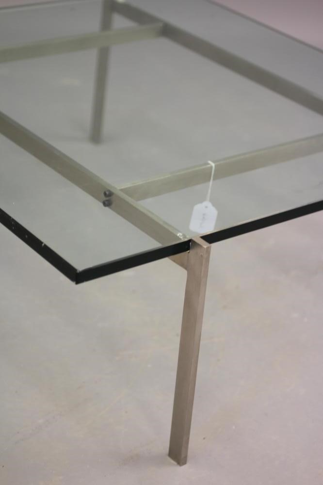 A GLASS AND POLISHED STEEL COFFEE TABLE, modern, the rounded square glass top on a square section Image