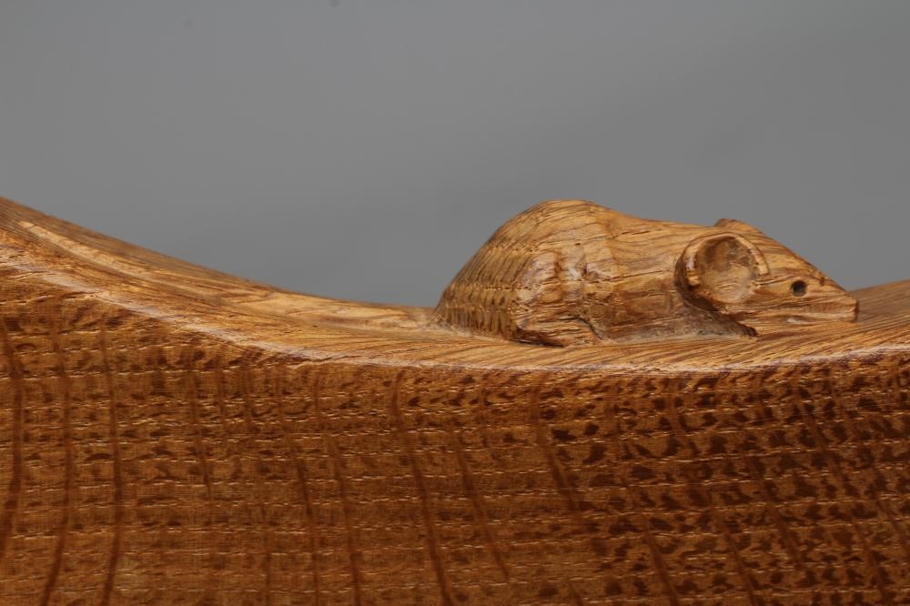 A ROBERT THOMPSON ADZED OAK COW STOOL, the dished kidney shaped top raised on three faceted splayed Image