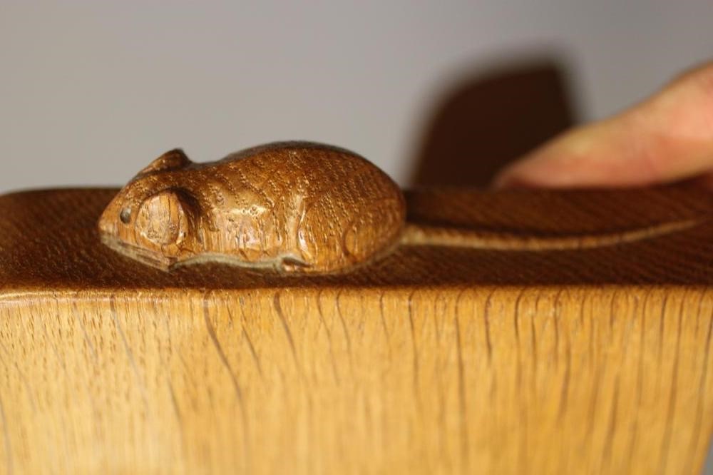 A ROBERT THOMPSON ADZED OAK WALL SHELF of rounded oblong form on ogee end brackets Image