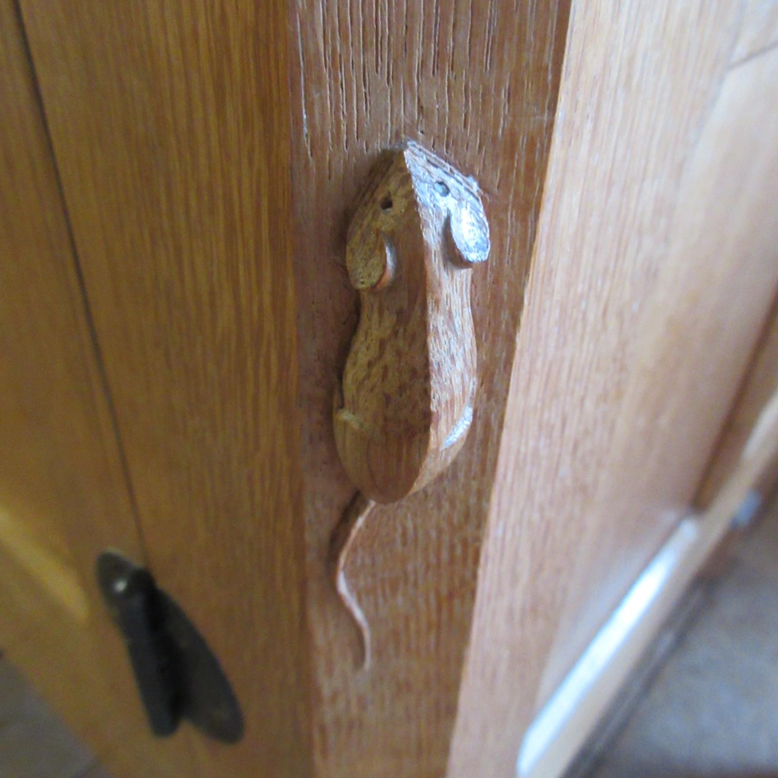 A ROBERT THOMPSON ADZED OAK SIDEBOARD of canted oblong form with ledge back Image