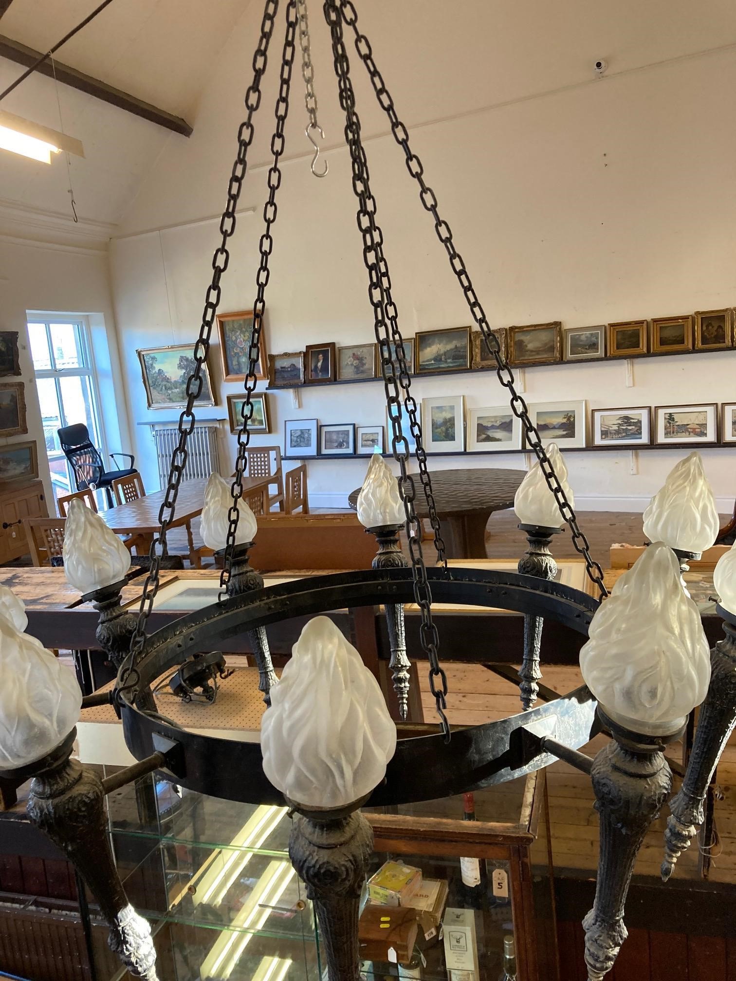 AN EBONISED METAL TEN LIGHT CEILING PENDANT, 20th century, the circlet suspended from chains and Image
