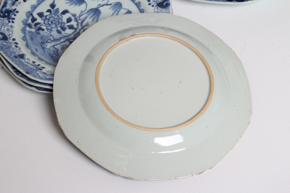 A SET OF SIXTEEN CHINESE PORCELAIN OCTAGONAL PLATES painted in underglaze blue with vases on a table Image