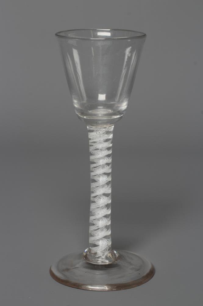 A LATE GEORGIAN CORDIAL GLASS, the rounded bucket bowl issuing from an opaque multi-ply central Image