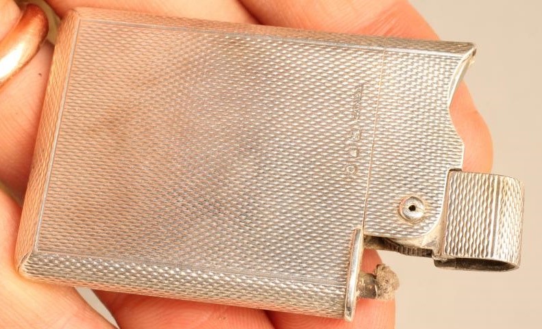 A SILVER CIGARETTE LIGHTER Image