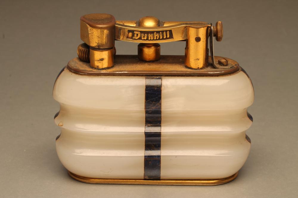 A DUNHILL WHITE ONYX TABLE LIGHTER of ribbed oblong form inset with lapis lazuli angles Image