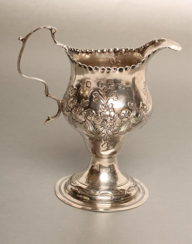 A GEORGE III SILVER CREAM JUG Image