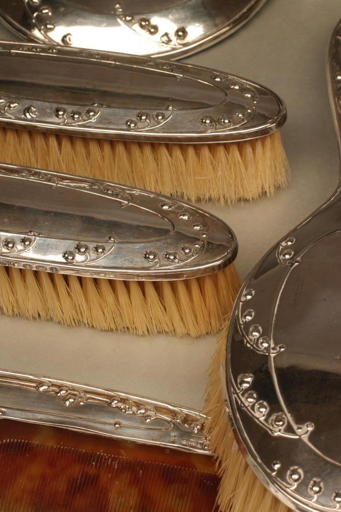 A COMPOSITE EDWARDIAN ART NOUVEAU SILVER SIX PIECE DRESSING TABLE SET Image