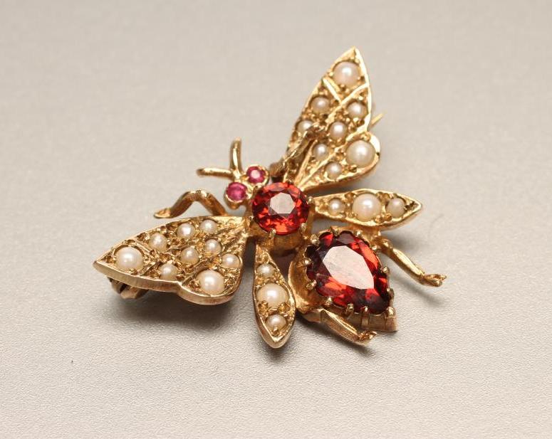 A 9CT GOLD NOVELTY FLY BROOCH with seed pearl set wings and garnet eyes Image