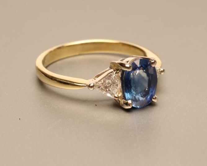A SAPPHIRE AND DIAMOND THREE STONE RING the oval facet cut sapphire claw set to shoulders each set Image