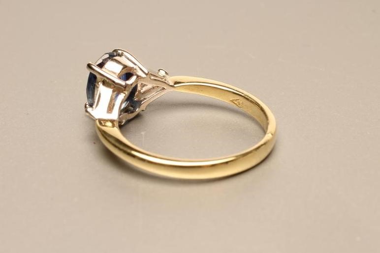 A SAPPHIRE AND DIAMOND THREE STONE RING the oval facet cut sapphire claw set to shoulders each set Image