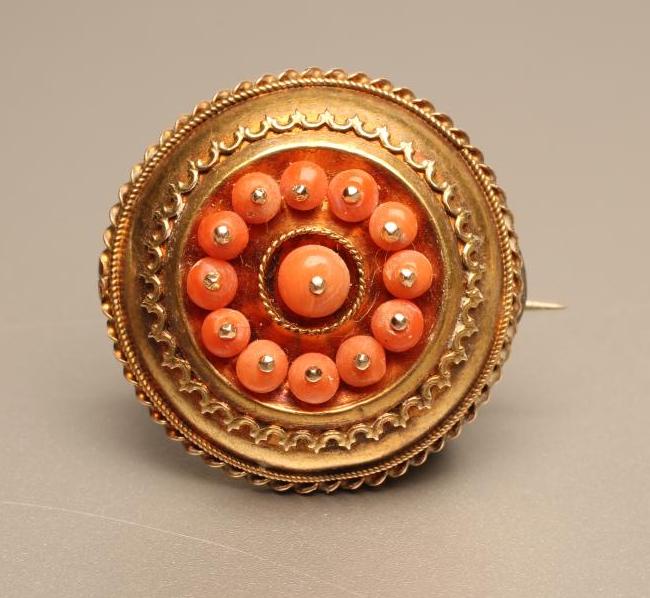 A VICTORIAN ETRUSCAN STYLE GOLD BOSS BROOCH centred by a cluster of thirteen pin set coral beads Image