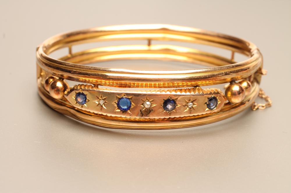 AN EDWARDIAN 9CT GOLD STIFF HINGED HOLLOW BANGLE of open form Image