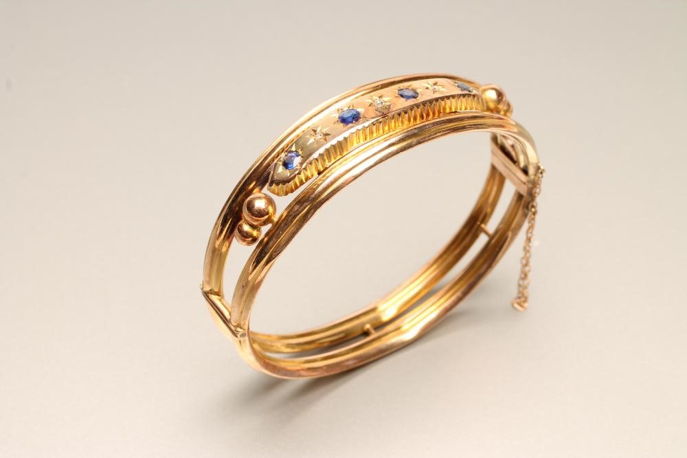 AN EDWARDIAN 9CT GOLD STIFF HINGED HOLLOW BANGLE of open form Image