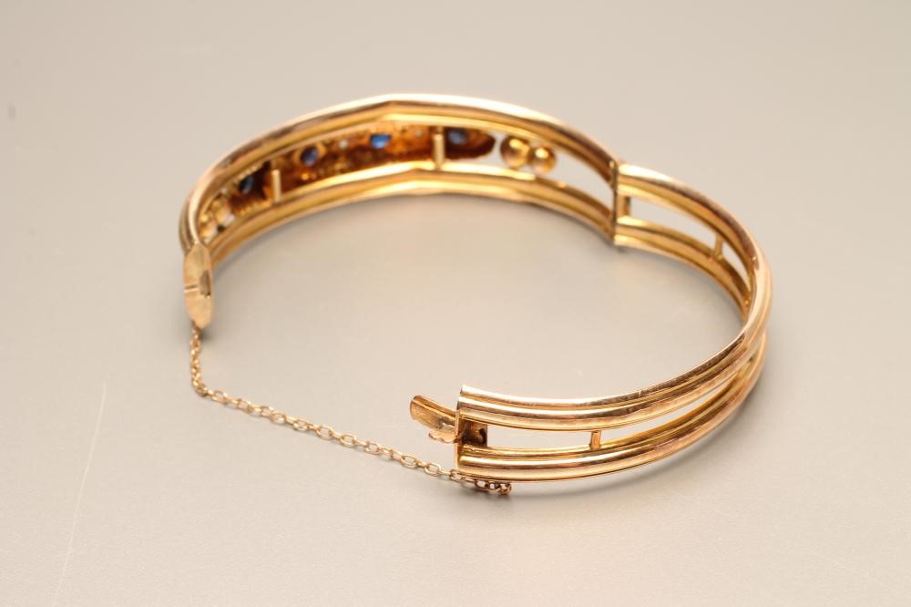AN EDWARDIAN 9CT GOLD STIFF HINGED HOLLOW BANGLE of open form Image
