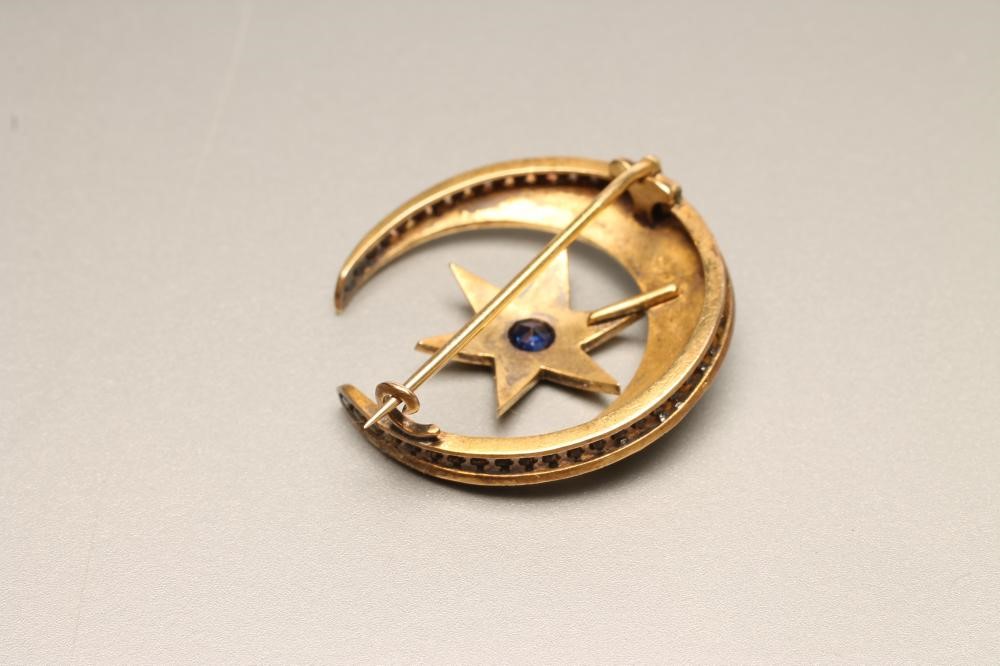 A VICTORIAN SEED PEARL CRESCENT BROOCH centred by a star gypsy set with a sapphire Image