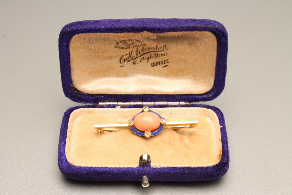 A LATE VICTORIAN BAR BROOCH centred by an oval polished coral panel within a blue enamel border set Image
