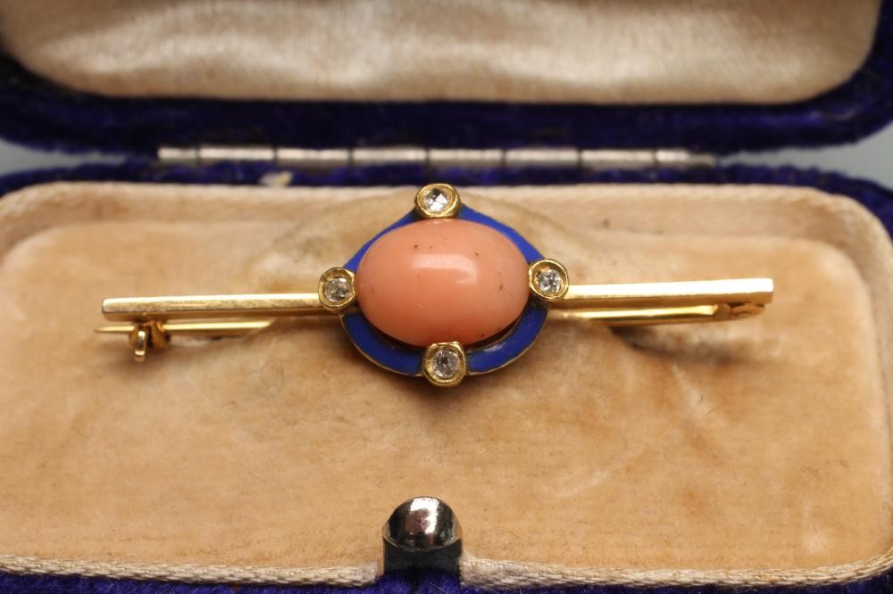 A LATE VICTORIAN BAR BROOCH centred by an oval polished coral panel within a blue enamel border set Image
