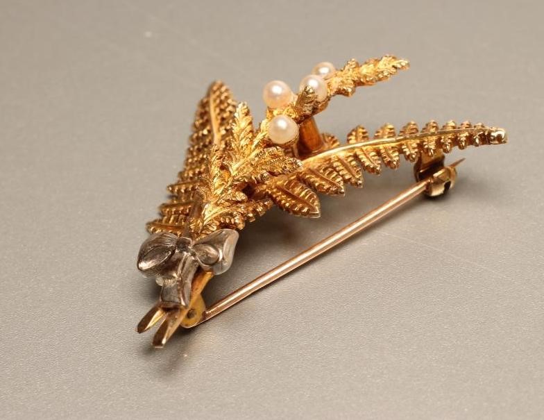 A 9CT GOLD AND SEED PEARL BROOCH as a pair of fern leaves and a branch set with four seed pearls Image