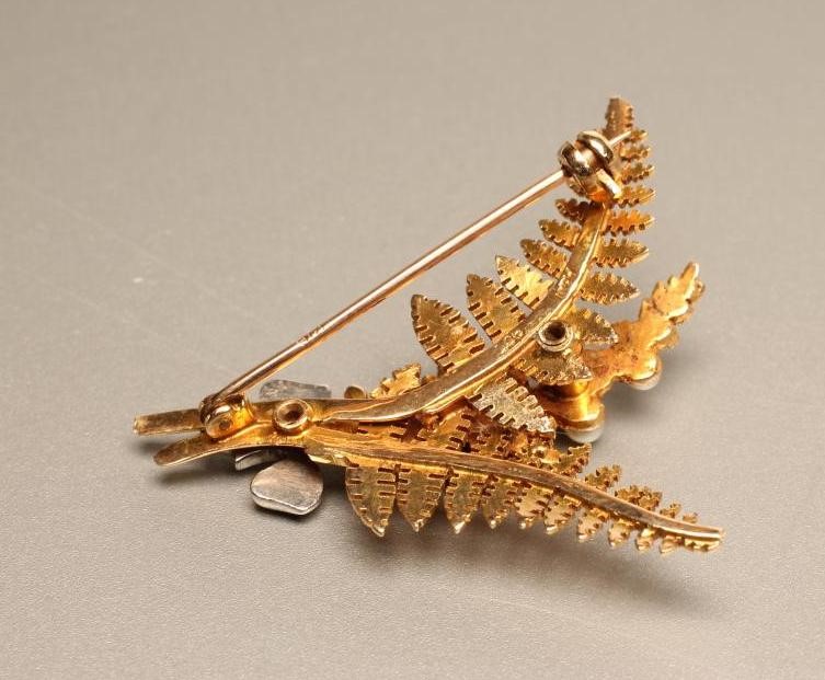 A 9CT GOLD AND SEED PEARL BROOCH as a pair of fern leaves and a branch set with four seed pearls Image