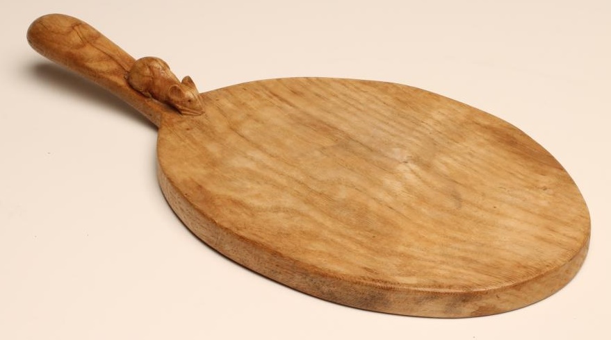 A ROBERT THOMPSON ADZED OAK CHEESE BOARD of oval form Image