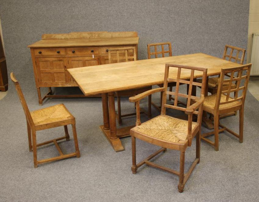 AN ARTS AND CRAFTS STYLE OAK DINING SUITE by Heals of London Image