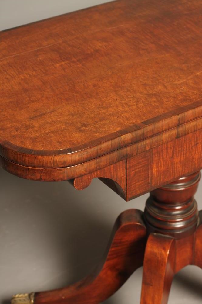 A REGENCY MAHOGANY FOLDING CARD TABLE of rounded oblong form with rosewood banding Image