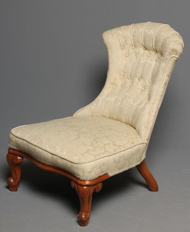 A VICTORIAN WALNUT FRAMED NURSING CHAIR button upholstered in an ivory floral weave Image