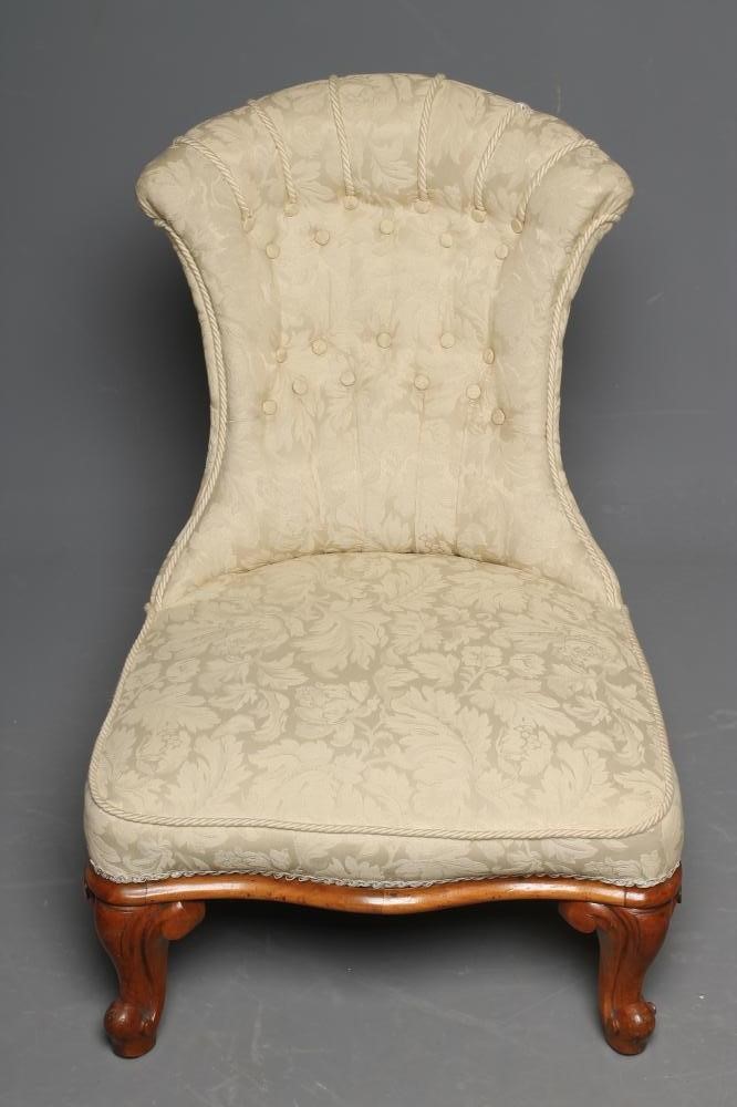 A VICTORIAN WALNUT FRAMED NURSING CHAIR button upholstered in an ivory floral weave Image