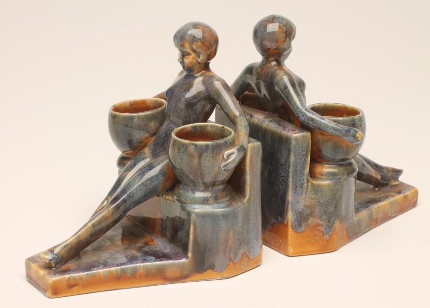 A PAIR OF ART DECO CONTINENTAL EARTHENWARE FIGURAL BOOKENDS Image