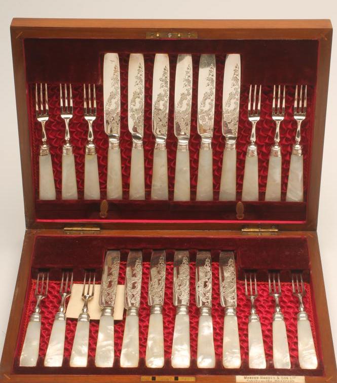 A SET OF TWELVE PAIRS OF SILVER PLATED DESSERT KNIVES AND FORKS with foliate scroll engraved blades Image