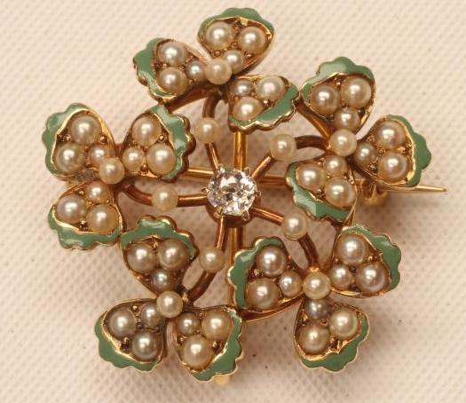 A VICTORIAN 14KT GOLD BROOCH/PENDANT centred by a claw set old cut diamond within green enamelled Image