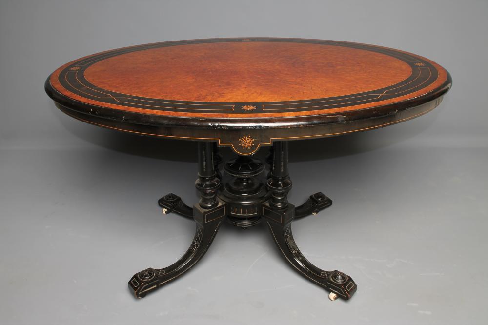 A VICTORIAN AMBOYNA AND EBONISED CENTRE TABLE of oval form in the Aesthetic taste Image