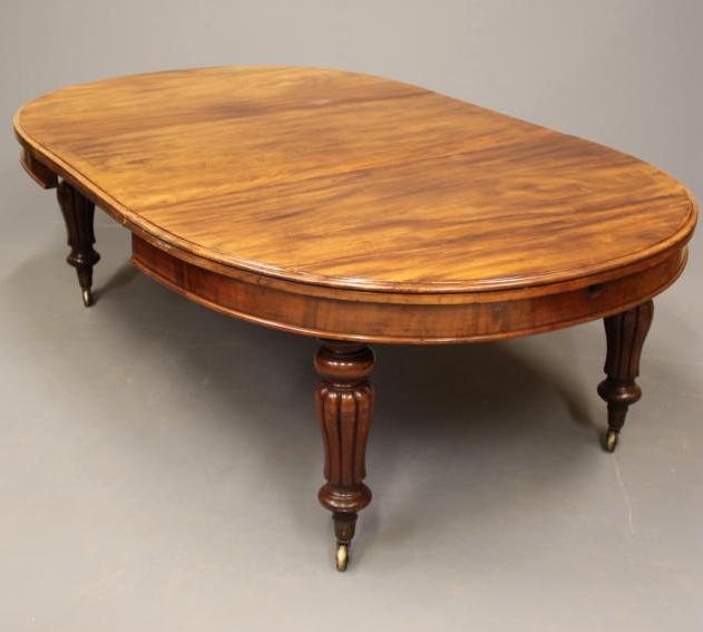 A VICTORIAN MAHOGANY EXTENDING DINING TABLE with wind out action and separate leaf Image