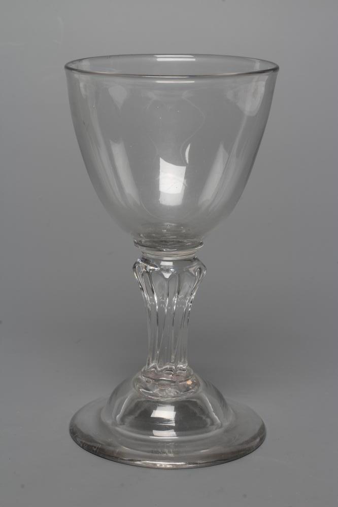 A GLASS GOBLET, late 18th century, the rounded bowl on a wrythen moulded flared cylindrical stem and Image