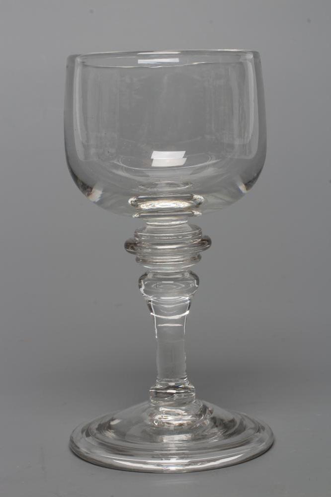 A MEAD GLASS, early 18th century, the plain cup bowl issuing from a triple ringed annular top knop Image