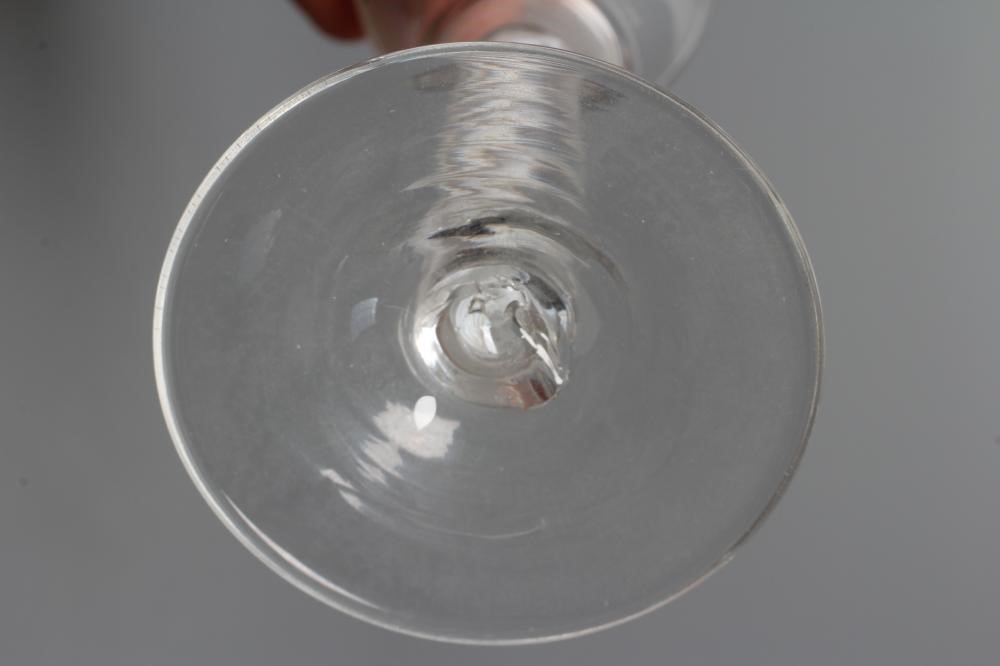 A CORDIAL GLASS, mid 18th century, the plain waisted bucket bowl on a single series opaque twist Image