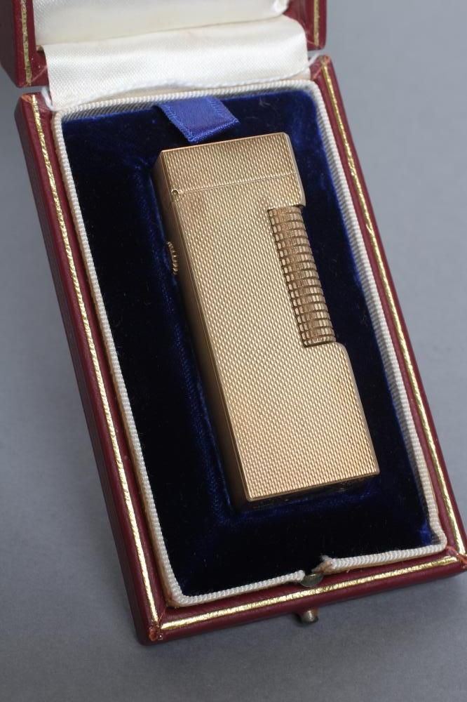 A DUNHILL 9CT GOLD ROLLAGAS CIGARETTE LIGHTER of plain oblong form with engine turning, 2 1/2" high, Image