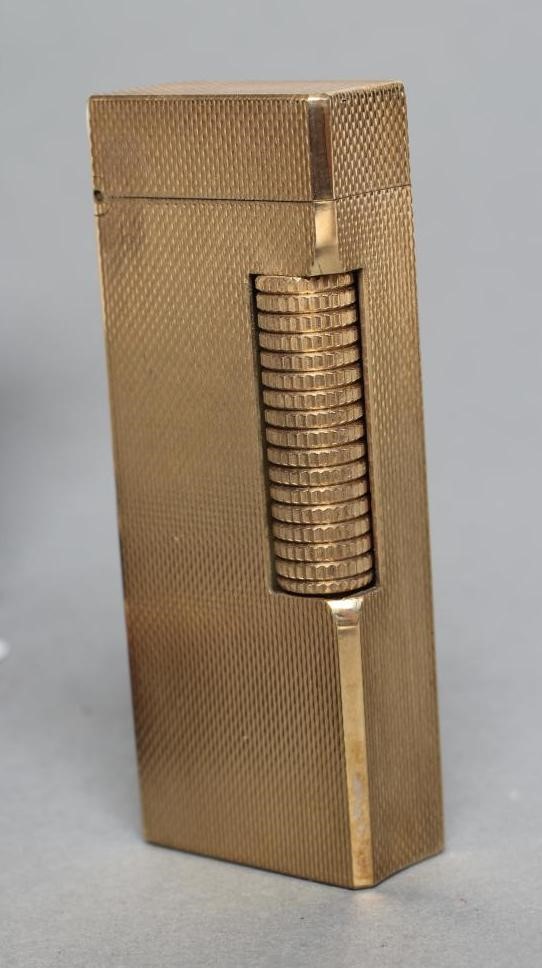 A DUNHILL 9CT GOLD ROLLAGAS CIGARETTE LIGHTER of plain oblong form with engine turning, 2 1/2" high, Image